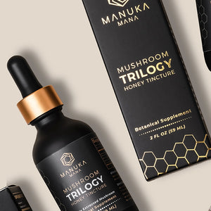 A tincture bottle of Manuka Mana's mushroom trilogy honey tincture is pictured next to its packaging.