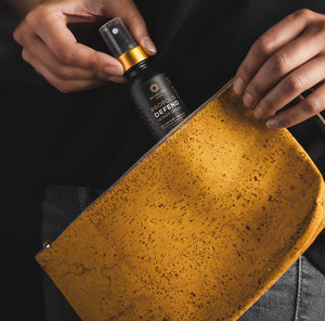 A bottle of Propolis DEFEND honey spray is being placed into a clutch..