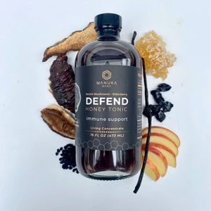 A bottle of Red Reishi DEFEND honey tonic is surrounded by its ingredients.