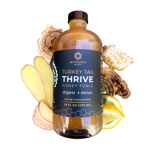 A bottle of Turkey Tail Thrive honey tonic is surrounded by its ingredients.