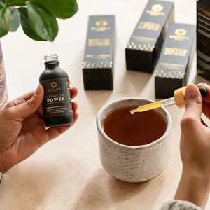 The Manuka Mana cordyceps tincture is pictured with a dropper full of it being dropped into a tea cup to demonstrate one of the two products in the energy bundle. 