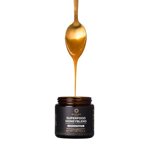 A spoon is drizzling the superfood honeyblend back into its jar to demonstrate one of the products that's included with the honeyblend trio package as well as the immunity bundle.